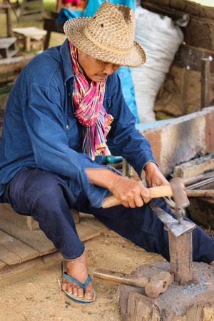 CHIANG MAI THAILAND - DECEMBER 29 2013:A blacksmith forging an iron piece on the anvilのeditorial素材