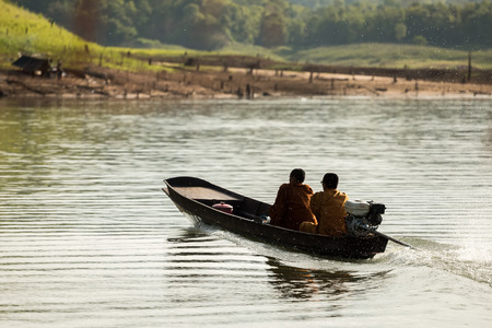Buddhist monks collecting alms in the morning by boat.の写真素材