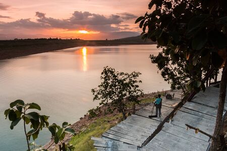 A Man standing shooting a beautiful sunrise.の写真素材