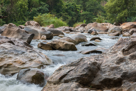 Beautiful River water flowing through stones and rocks at dawnの写真素材