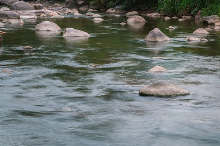 Beautiful River water flowing through stones and rocks at dawn