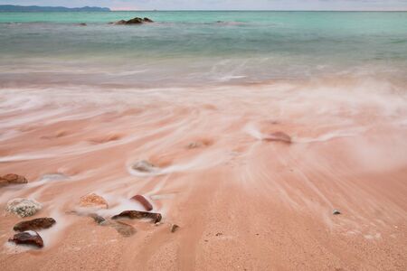 Soft wave of blue ocean on sandy beach. Background.