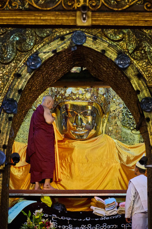 MANDALAY, MYANMAR - OCTOBER 15 : The senior monk wash Mahamuni Buddha image in ritual of the Buddha image face wash on OCTOBER 15, 2016 at Mahamuni temple in Mandalay, Myanmar.This ritual commences every morningのeditorial素材