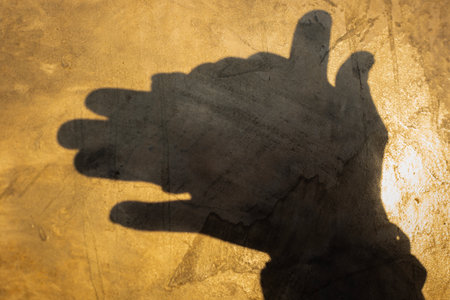 Hand Shadow: The captivating shadow of a hand, expertly molded to depict a playful dog on a textured...