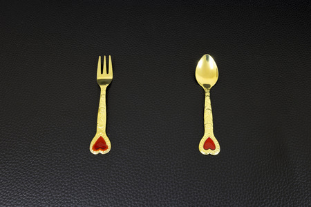 Gold Spoon and Fork on dark backgroundの写真素材