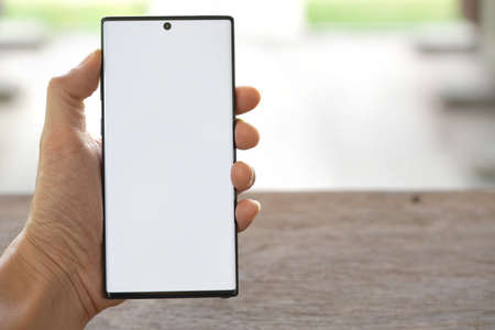 The man's hand is holding a New smartphone.