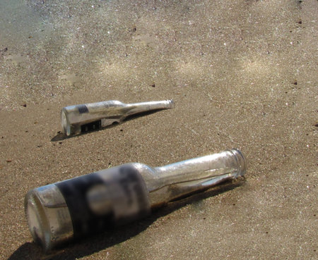 two bottles garbage on the sandの写真素材