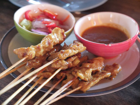 pork satay skewer in a dish with sauceの写真素材