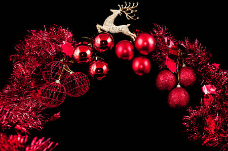 Christmas background with a red ornament on black backgroundの写真素材