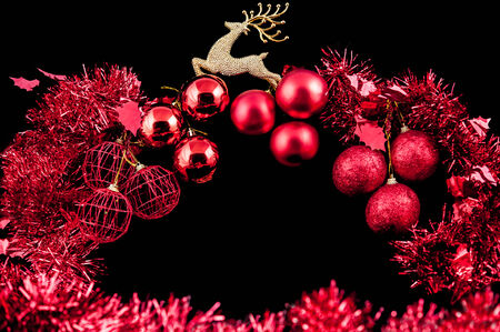 Christmas background with a red ornament on black backgroundの写真素材