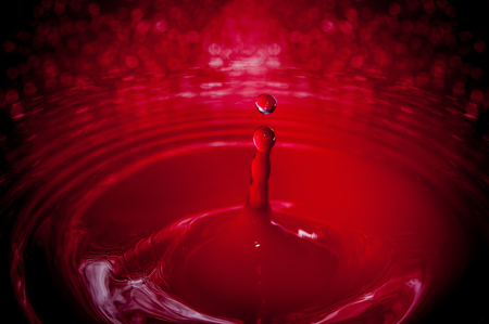 Photo of a drop of water on a red backgroundの写真素材
