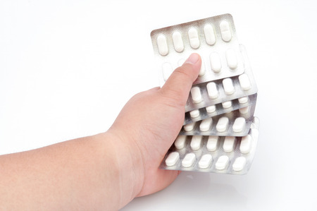 Hand holding a stack of pills