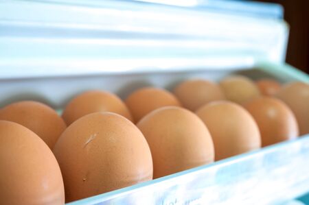 Eggs on a white shelf of the refrigerator