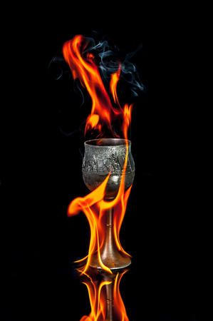 Wine goblet with Fire flames on black backgroundの写真素材
