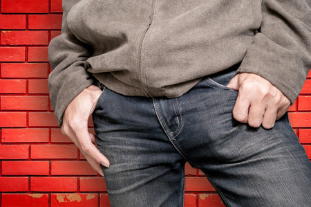 Young fashion man wearing jeans on brick wall backgroundの写真素材