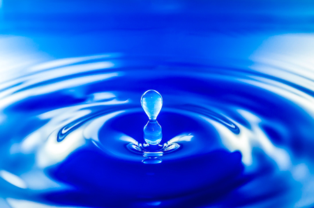 Photo of drop of water on blue background