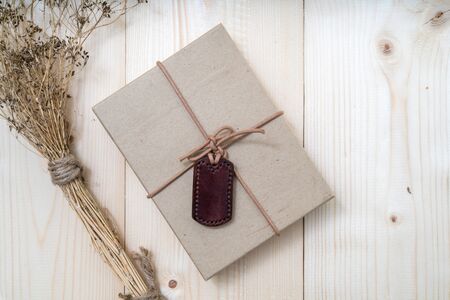 Gift boxes with labels made of leather with rope on gunny sack vintage style backgroundの写真素材