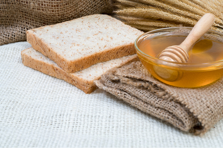 cup honey on sackcloth and Bread wheatの写真素材