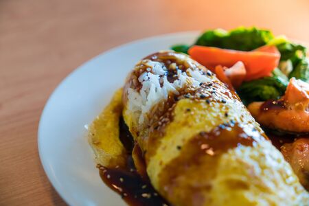 Flavored Fried Rice in an Omelet Wrapping with Grilled Salmon Fillet /selective focus.の写真素材