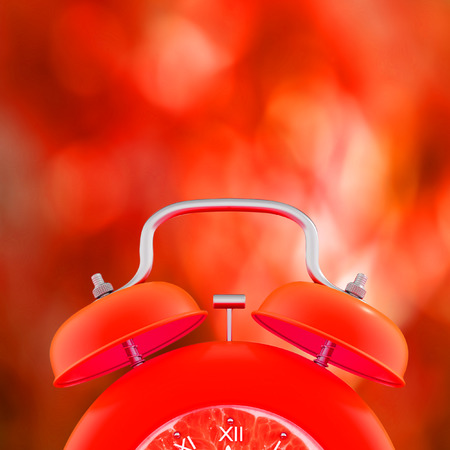 red alarm clock on fire blurred background and copy space for your text.の写真素材