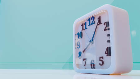 White square clock on desk in green pastel office. Yellow background and copy space for your text. Minimal idea concept, 3D Render.の写真素材