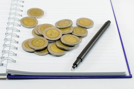 THB Cash ,coin thailand and pen on notebook