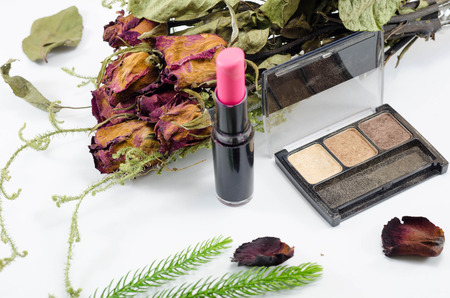 Set of decorative cosmetics and dried red roseの写真素材