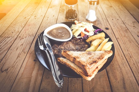 pork steak Potato bread on wood tableの写真素材
