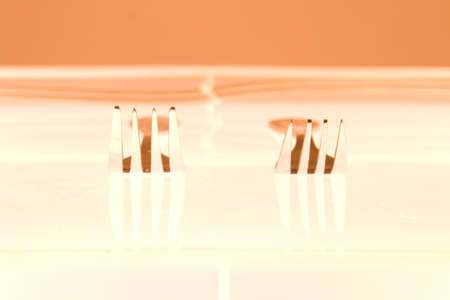 Two silver fork on orange backgroundの写真素材
