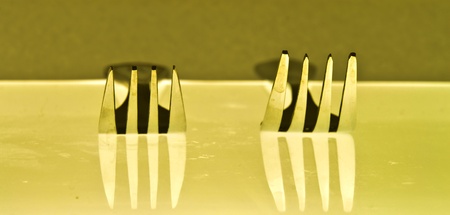 Two silver fork on yellow backgroundの写真素材