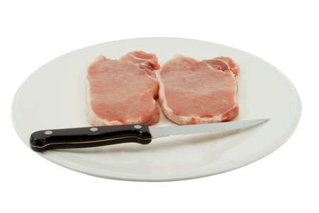 Plate with two pieces of pork and a knife の写真素材