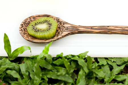 Kiwi sliced in spoon on a cutting board の写真素材