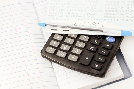Papers on financial figures with calculator and pen の写真素材