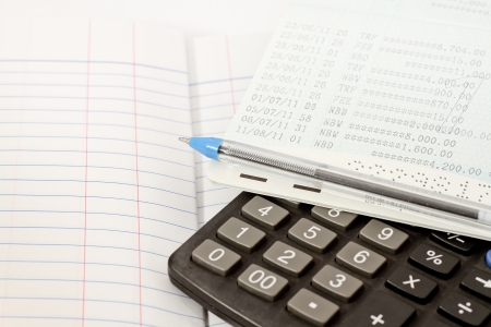 Papers on financial figures with calculator and pen の写真素材