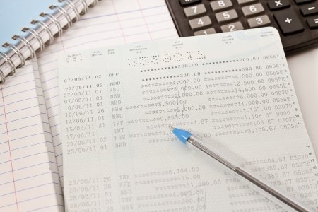 Papers on financial figures with calculator and pen の写真素材