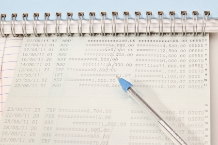 Papers on financial figures with book and pen の写真素材