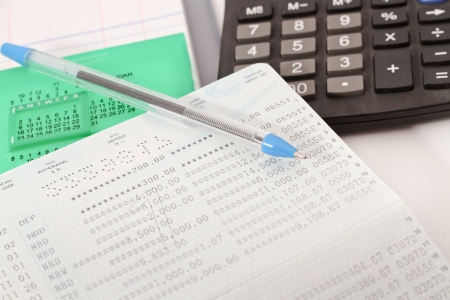 Papers on financial figures with calculator and pen の写真素材