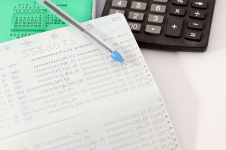 Papers on financial figures with calculator and pen の写真素材