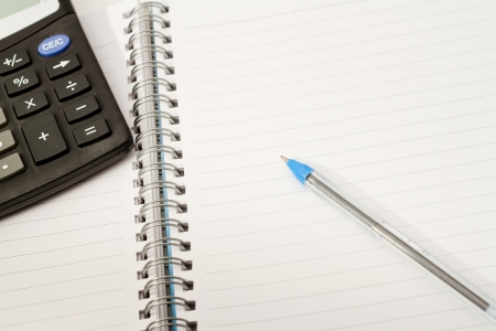 Papers on financial figures with calculator and pen の写真素材