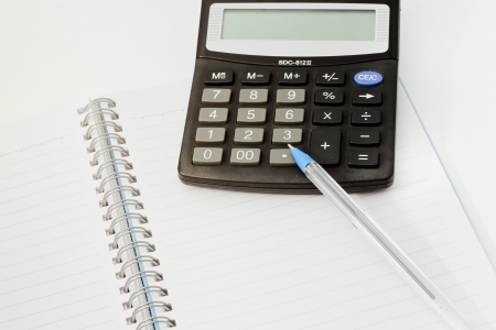 Papers on financial figures with calculator and pen の写真素材