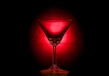 Empty cocktail glass on shiny red の写真素材