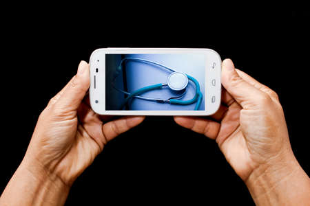 Hand holding white smartphone with blank screen.の写真素材