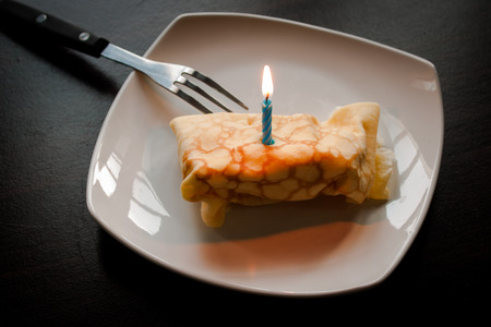Dessert crepes on a white plate. Crepe Cake Candle.の写真素材