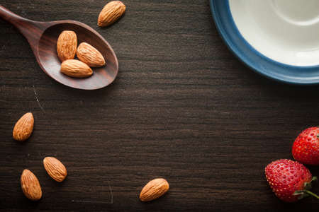 Almond and strawberries on dark wood background. Preparing food.の写真素材