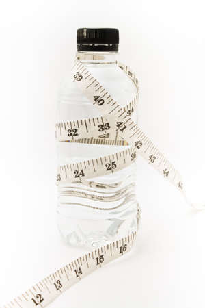 Drinking water. Tape measure waist as a symbol of diet.の写真素材