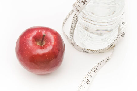 Apple and water. Tape measure waist as a symbol of diet.の写真素材