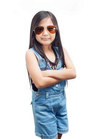 Little girl posing with arms crossed on white background.の写真素材