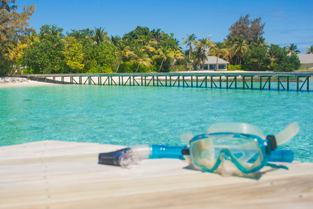 Pier by the ocean and snorkel mask on wooden. Tropical paradise for diving. Focus of pier.