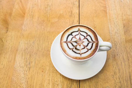 Cup of hot chocolate with beautiful art on wooden table background.の写真素材