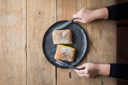 Cheese sandwich served on a plate, Female hands with cutlery.の写真素材